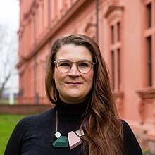 Portraitfoto einer lächelnden Frau vor einem Gebäude